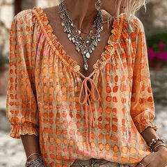 Women's relaxed orange polka dot blouse with a lace-up V-neck and three-quarter puff sleeves
