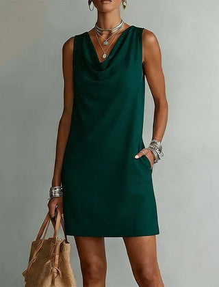 Women's green sleeveless pocket mini dress with a draped neckline.