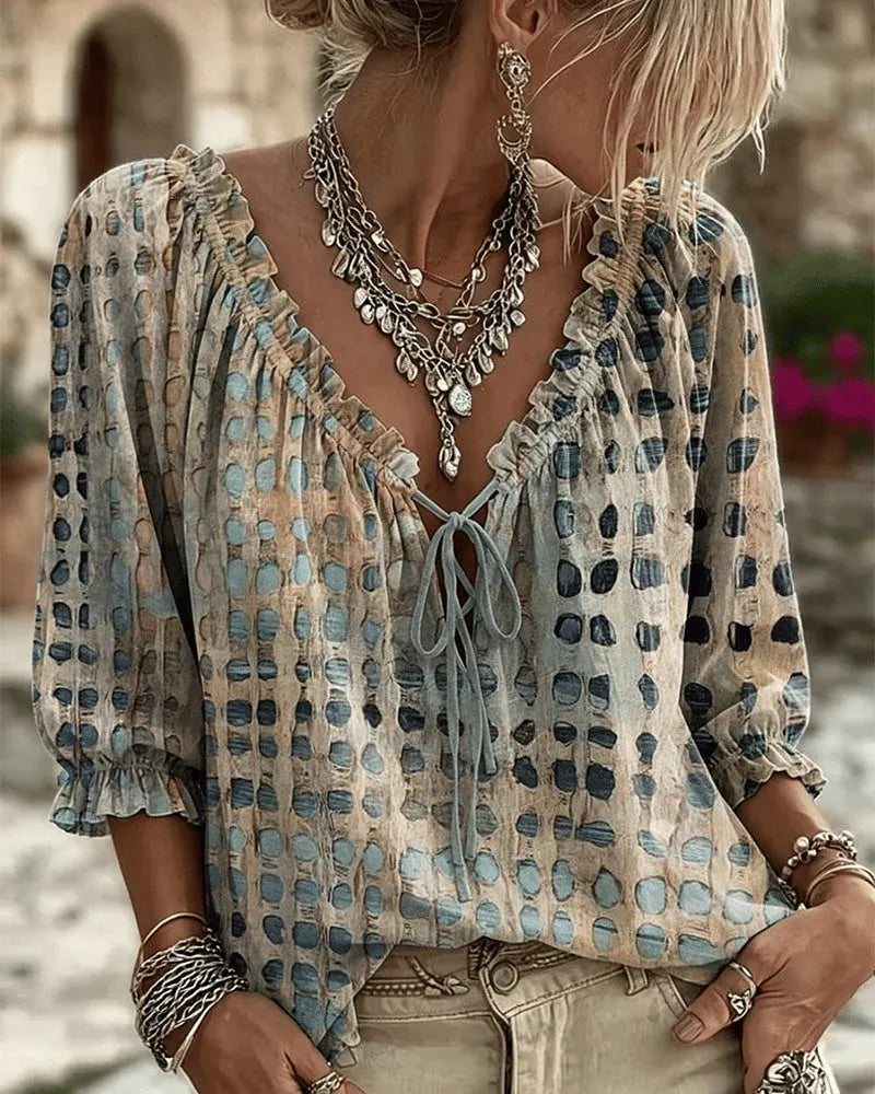 Women's relaxed blue polka dot blouse with a lace-up V-neck and three-quarter puff sleeves