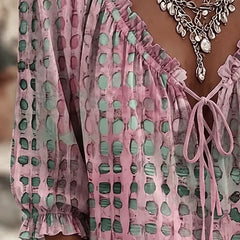Close-up of the lace-up V-neck and polka dot print on the Araminta blouse
