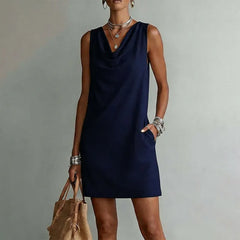 Women's navy blue sleeveless pocket mini dress with a draped neckline.
