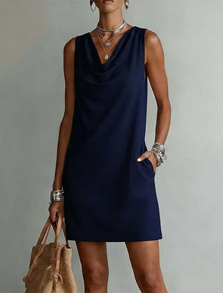 Women's navy blue sleeveless pocket mini dress with a draped neckline.
