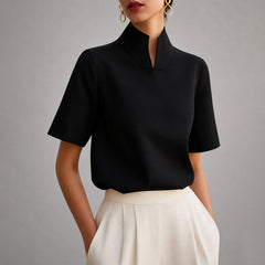 Women's black short-sleeve structured blouse with a V-cut mock neck.