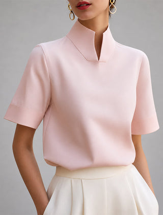 Women's pink short-sleeve structured blouse with a V-cut mock neck.