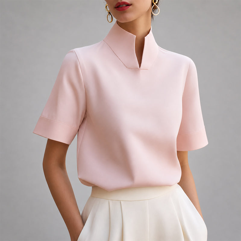 Women's pink short-sleeve structured blouse with a V-cut mock neck.