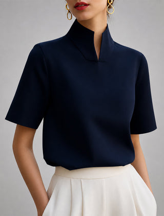 Women's blue short-sleeve structured blouse with a V-cut mock neck.
