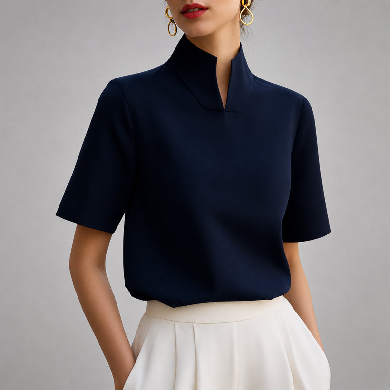 Women's blue short-sleeve structured blouse with a V-cut mock neck.