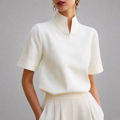 Women's white short-sleeve structured blouse with a V-cut mock neck.