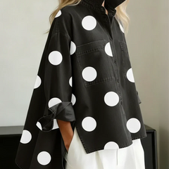 Women's black polka dot button-up shirt with spread collar and chest pockets.